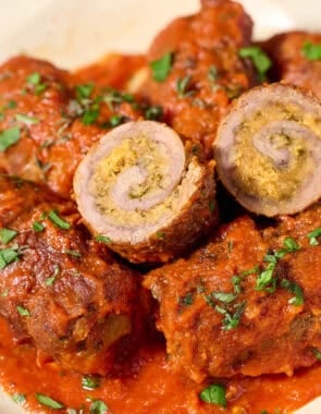 Beef braciole with marinara sauce on a plate.