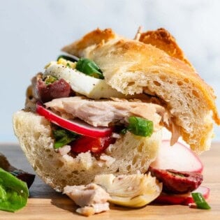 A pan bagnat on a wooden cutting board.