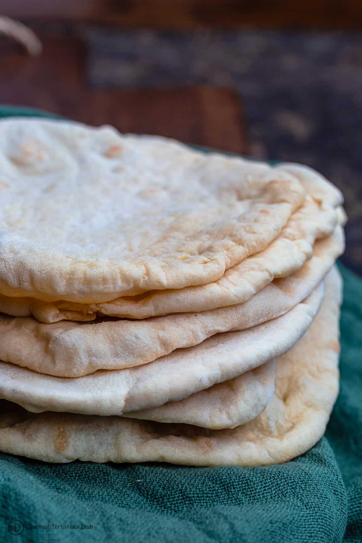 Stack of pita bread over a kitchen towel