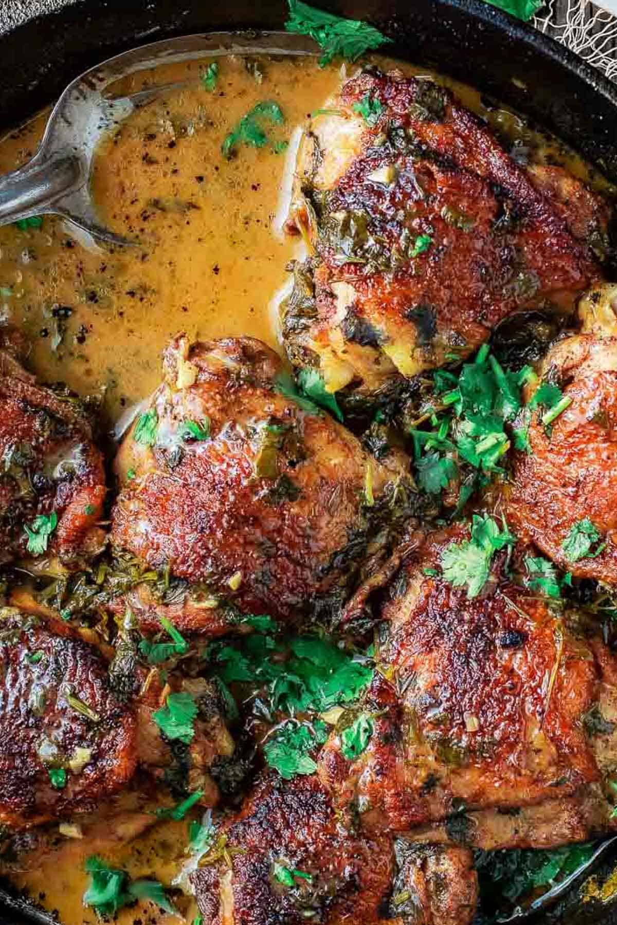 Overhead shot of cilantro lime chicken thighs in a cast iron skillet.
