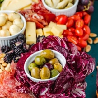 close up of a large antipasto platter with a selection of meats, cheeses, fruits, vegetables and nuts.