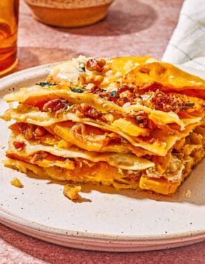 A close up of a slice of butternut squash lasagna on a plate.