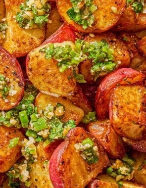 A close up of crispy red skinned potatoes drizzled with walnut cilantro chili sauce.