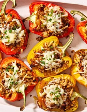 Several grilled stuffed peppers on a serving platter.