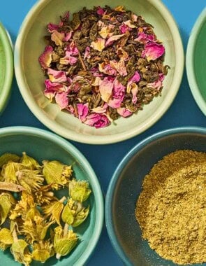 Five bowls, each containing different flavored tea leaves.
