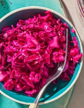 A bowl of pickled cabbage with a fork.