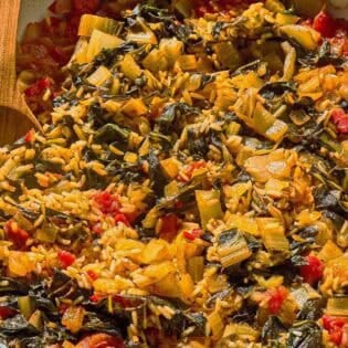 Swiss chard in a skillet with a wooden spoon.